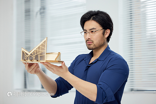 建筑設(shè)計(jì)師手拿建筑模型研究